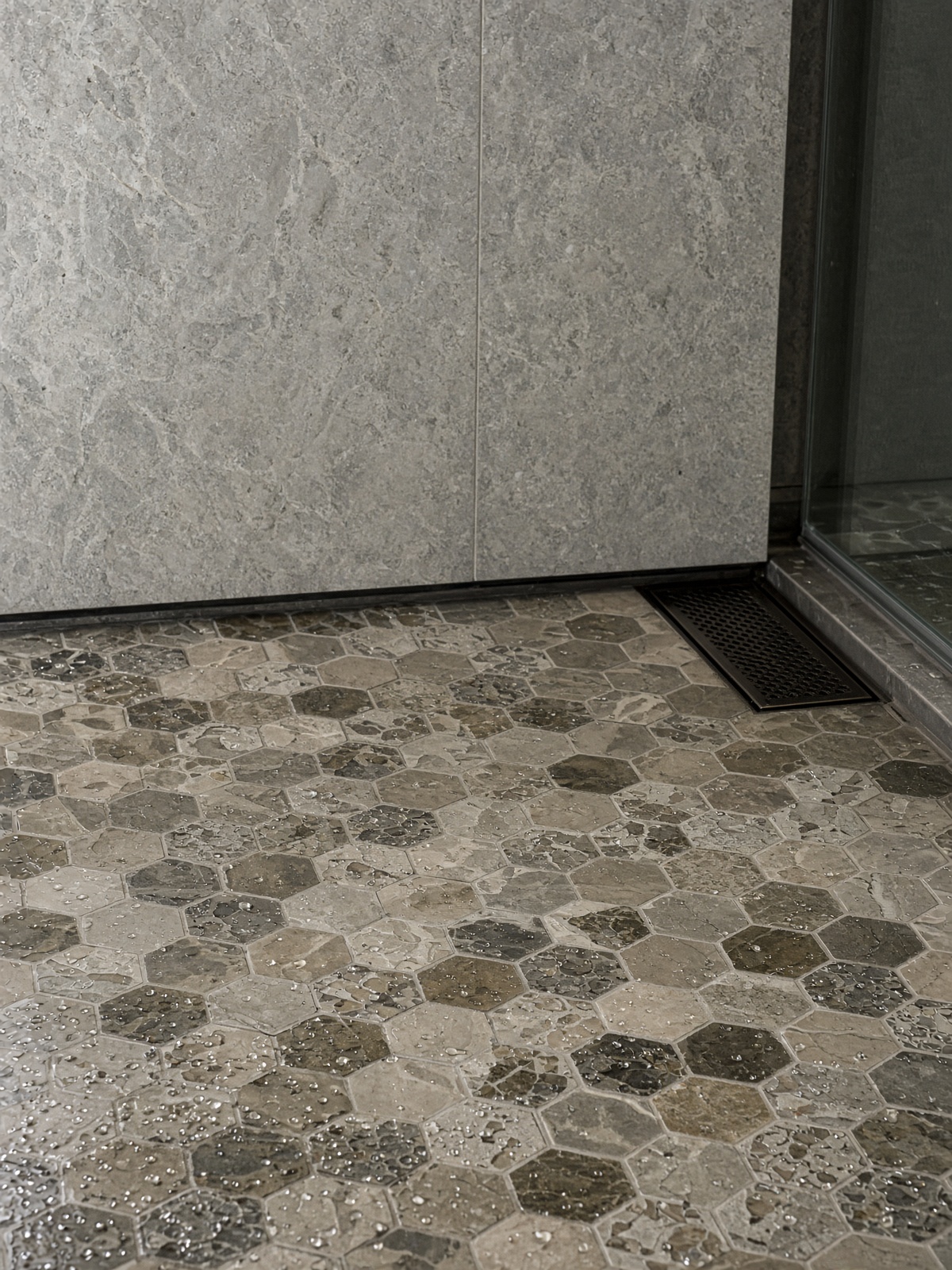 Mosaic tile floor meeting a stone slab wall